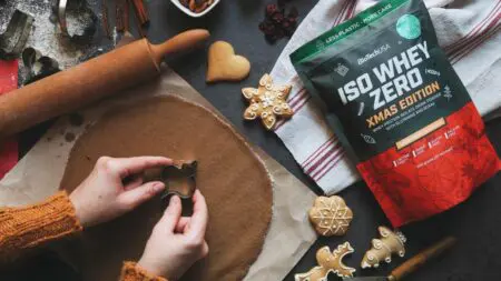 Platos festivos saludables con ensaladas, verduras asadas, salmón al horno y frutas frescas en una mesa navideña decorada.
