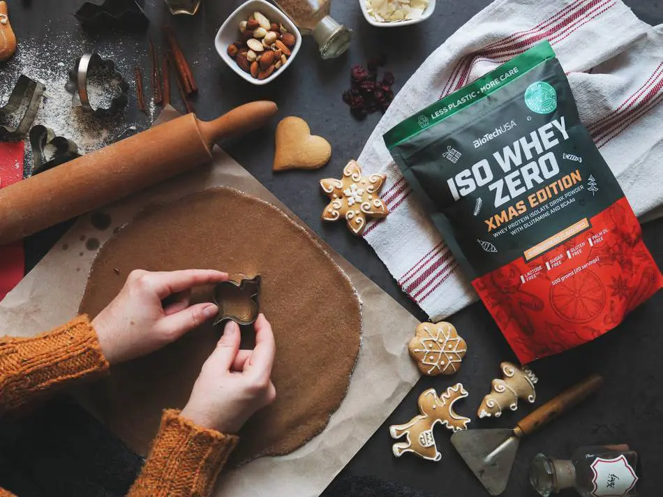 Platos festivos saludables con ensaladas, verduras asadas, salmón al horno y frutas frescas en una mesa navideña decorada.