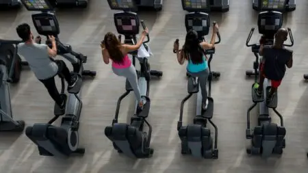 Personas haciendo elípticas en el gimnasio aprovechando sus beneficios para mantenerse en forma.