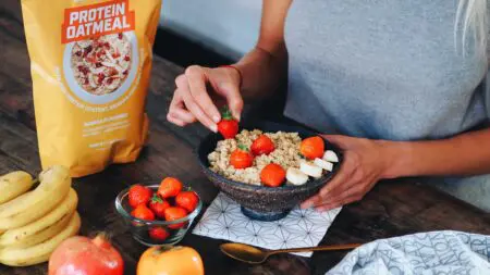 Deportista en el gimnasio comiendo un snack proteico como parte de su dieta de definición muscular