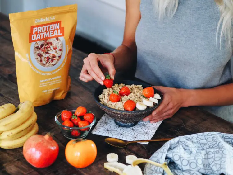 Deportista en el gimnasio comiendo un snack proteico como parte de su dieta de definición muscular