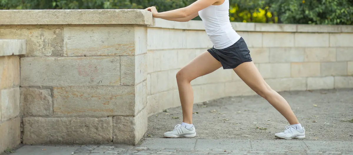 Persona estirando la pierna tras sufrir un calambre en el gemelo, mostrando técnicas de alivio y prevención para este tipo de molestias musculares.