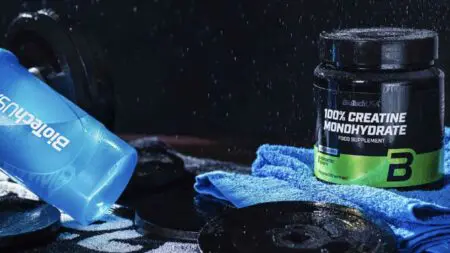 Deportista sujetando suplemento de creatina antes del entrenamiento