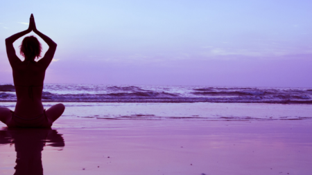 Mujer practicando una de las posturas de yoga avanzadas en un entorno natural, enfocada y en equilibrio.
