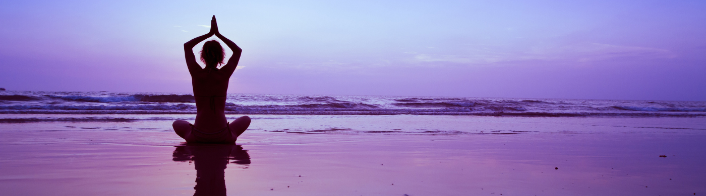 Mujer practicando una de las posturas de yoga avanzadas en un entorno natural, enfocada y en equilibrio.