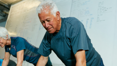 Hombre mayor haciendo ejercicio con pesas ligeras tras tomar creatina, reflejando sus beneficios en fuerza y vitalidad.