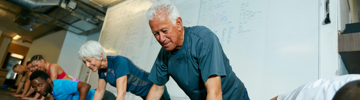 Hombre mayor haciendo ejercicio con pesas ligeras tras tomar creatina, reflejando sus beneficios en fuerza y vitalidad.
